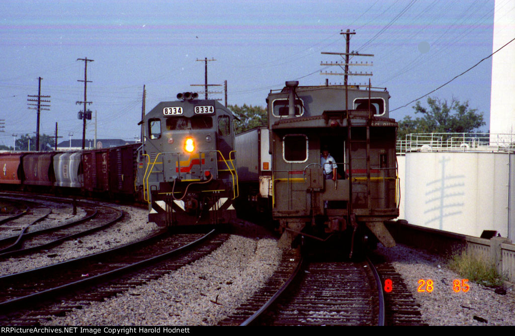 SBD 8334 leads a southbound train past the caboose on a northbound piggyback train